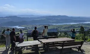 Widok z góry Wdżar na jezioro i góry. Grupa turystów podziwia panoramę.