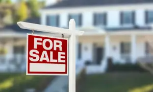 Cartello "For Sale" davanti a una casa. Si può vendere un immobile senza successione, una nuova opportunità per chi cerca casa.