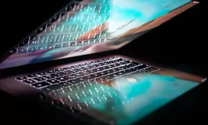 Podświetlana klawiatura laptopa odbija się w ekranie, tworząc efekt 287 kk.