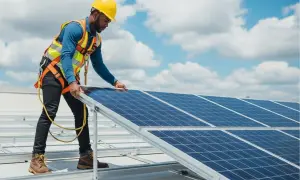 Técnico instala placas solares en casa de campo, asegurando energía limpia bajo un cielo azul con nubes.