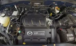 Silnik V6 DOHC 24-zaworowy w Mazda Tribute. Widoczny zbiornik płynu chłodniczego, akumulator i elementy układu dolotowego.