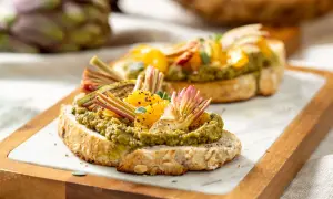 Deliziosi crostini con paté di carciofi, spicchi d'arancia e finocchietti croccanti su pane integrale tostato.