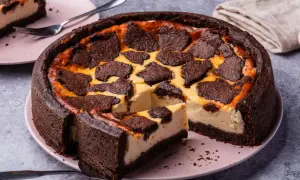 Ein saftiger russischer Zupfkuchen mit dunklem Schokoladenboden und cremiger Käsemasse, belegt mit zupfartigen Schokoladenstückchen.