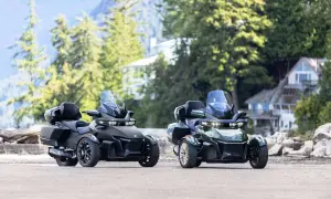 Dwa nowoczesne, trójkołowe motocykle, czarny i zielony, stoją obok siebie. To ciekawe rodzaje motocykli, idealne na podróż.