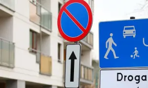 Znak B35 zakazu zatrzymywania się i postoju, znak kierunku jazdy na wprost oraz niebieska tablica z piktogramami pieszych i samochodu.