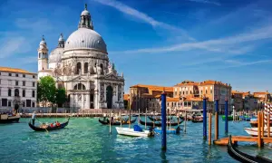 Gondole płynące po wodzie przed Bazyliką Santa Maria della Salute. Tak właśnie wygląda Wenecja, miasto na wodzie.