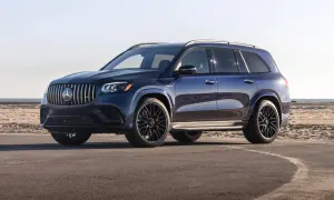 Lśniący, granatowy Mercedes-Benz GLS z czarnymi felgami stoi na asfalcie przy plaży.