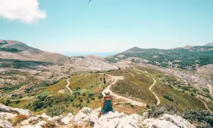 Frauen mit Hut genießen Aussicht auf bergige Landschaft. Ein perfekter Ort für Urlaub in Europa Geheimtipps.