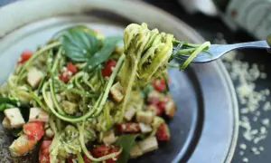 Délicieuses pâtes aux légumes sautés, un plat coloré et sain avec des courgettes en spirales, des tomates cerises et du basilic frais.