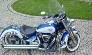 Błękitno-biały Yamaha Road Star 1700 lśni chromem na brukowanym podjeździe, gotowy na przygodę.