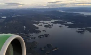 Flugzeugfenster mit Blick auf norwegische Schärenlandschaft. Gute Widerøe Airline Erfahrungen auf dieser Route.