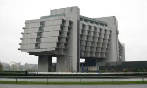Monumentalny budynek w stylu brutalizm, z betonową fasadą i charakterystycznymi, wystającymi elementami.