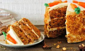 Delicioso carrot cake receta original inglesa, con capas de bizcocho y crema, decorado con zanahorias de mazapán.