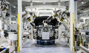 Roboterarme montieren ein Autoteil in einer Fabrik. Bosch KI steuert die präzisen Bewegungen.