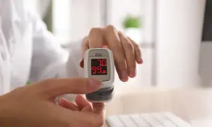 Pulsoksymetr na palcu pokazuje 99% saturacji, co jest dobrym wynikiem i zapobiega hipoksemii.