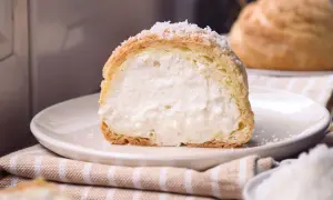 Bignè ripieno di crema soffice, cosparso di zucchero a velo che ricorda fiocchi di neve.