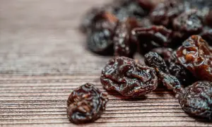 Garść rodzynek na drewnianym tle. Zastanawiasz się nad rodzynki kcal?