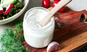 Ein Glas cremiges Sylter Dressing mit Dill und Knoblauch, bereit für einen frischen Salat.