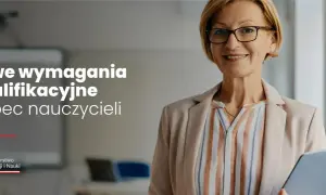 Uśmiechnięta nauczycielka w okularach trzyma tablet w sali lekcyjnej.