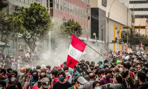 Tłum ludzi na ulicy w Peru, z flagą narodową i dymem. Czy w Peru jest bezpiecznie? Trudno ocenić po tym zdjęciu.