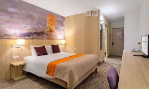 Pokój hotelowy z łóżkiem, tapetą z bursztynem i widokiem na morze, idealny na pobyt w Posejdon Gdańsk.
