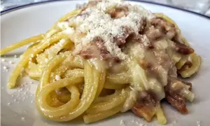 Un piatto di spaghetti alla carbonara, cremosi e ricchi di guanciale croccante, spolverati di pecorino.