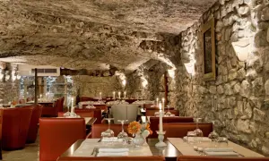 Atmosfera suggestiva in una grotta, ideale per scoprire i migliori ristoranti a Vieste. Tavoli apparecchiati con candele e fiori.