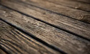Närbild på träplankor, redo för att såpskura altan. Vackert åldrat trä med synliga ådringar.
