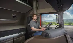 L'intérieur d'un camion DAF XG, avec un chauffeur souriant au volant, prêt pour un long voyage.
