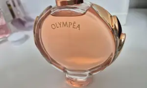 Olympea Paco Rabanne 80ml, w różowym odcieniu, otoczona złotymi zdobieniami.