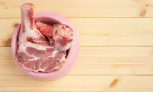 Surowe mięso i kości w różowej misce. Idealne, jakie mięso dla szczeniaka na początek przygody z BARF.