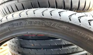 Profil opony 90/90-21M/C 54H. Widok z bliska na bieżnik i oznaczenia rozmiaru opony motocyklowej.