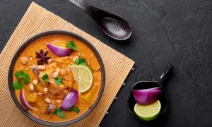 Aksamitna, żółta pasta curry z kurczakiem, orzeszkami ziemnymi, limonką i czerwoną cebulą.