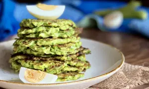 Pila di rosti di zucchine dorati, guarnita con spicchi di uovo sodo. Un piatto leggero e gustoso.