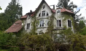 Maison abandonnée envahie par la végétation, parfaite pour faire de l'urbex. Toit endommagé, fenêtres brisées, un lieu chargé d'histoire.