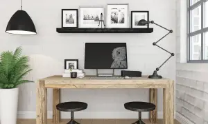 Przytulne biuro z drewnianym biurkiem, monitorem z sową, lampą i rośliną.