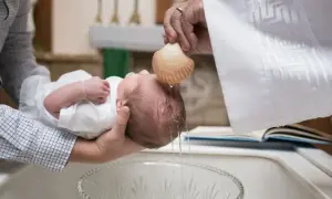 Chrzest dziecka, woda spływa z muszli na główkę. Pytanie, czy chrzestni mogą być tej samej płci, jest tu nieistotne.