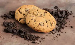 Due golosi crumble cookies con gocce di cioccolato, circondati da pezzetti di cioccolato fondente. La ricetta perfetta per un momento di dolcezza.