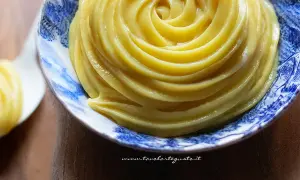 Crema pasticcera senza uova, liscia e vellutata, servita in una ciotola decorata con motivi blu.