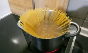 Długie nitki spaghetti gotują się w garnku, tworząc idealną bazę do pysznego dania. Oto jak zrobić spaghetti!