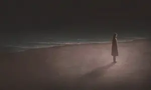 Una persona sola en la playa, contemplando el mar. Reflexiona sobre las cosas que tienes que hacer antes de morir.