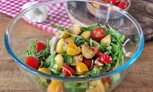 Salade colorée avec pommes de terre rôties, tomates cerises et roquette. Une option légère pour une salade pour maigrir du ventre.