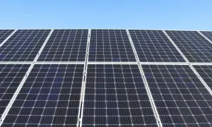 Duża instalacja PV pod błękitnym niebem. Panele słoneczne tworzą równą, ciemną powierzchnię, gotową do produkcji czystej energii.