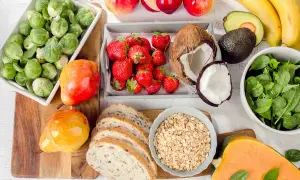 Zdrowe produkty na talerzu: brukselka, truskawki, jabłka, banany, awokado, szpinak, dynia, gruszki, chleb i płatki owsiane. Idealne składniki na dietę 1800 kcal.