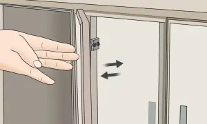 Mano ajustando la puerta de un armario con bisagras.