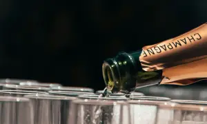 Versando champagne in bicchieri, la temperatura servizio è perfetta per un brindisi.