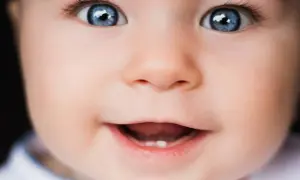 Occhi azzurri e un sorriso che promette gioia in questa vista neonati. Un piccolo dente spunta, segno di crescita.