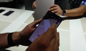 Ręka trzyma smartfon z włączoną funkcją AR Emoji. Widać ikonę "AR Emoji" na ekranie.