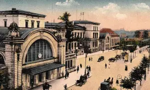 Dawny dworzec w Katowicach z epoki, z dorożkami i pieszymi na brukowanym placu.