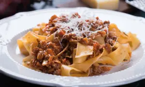 Pappardelle z sosem bolognese, posypane parmezanem. Idealny przepis na spaghetti bolognese oryginalny.